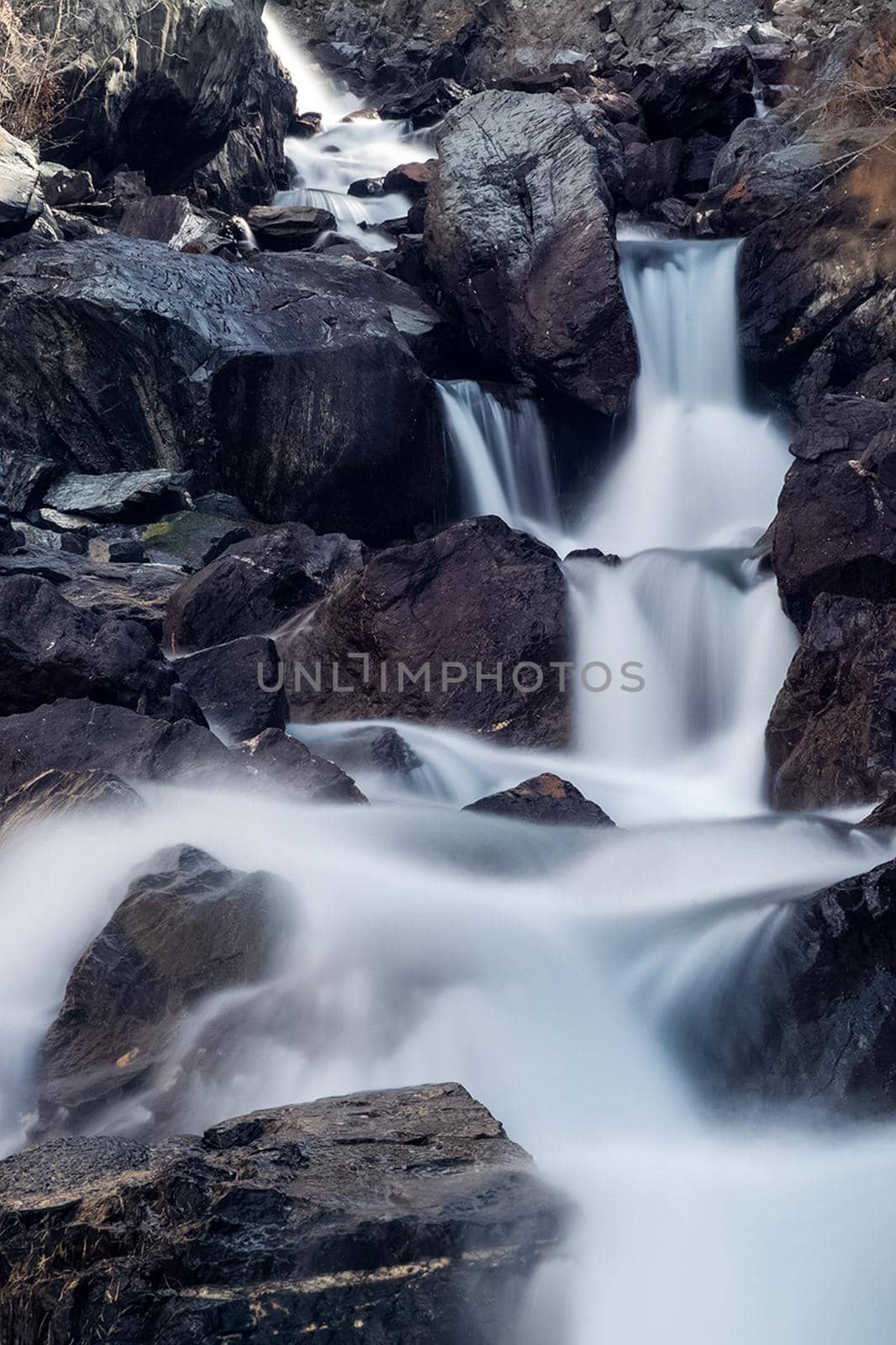 A small waterfall on a mountain river in the Altai. The Altai Mountain Rivers.