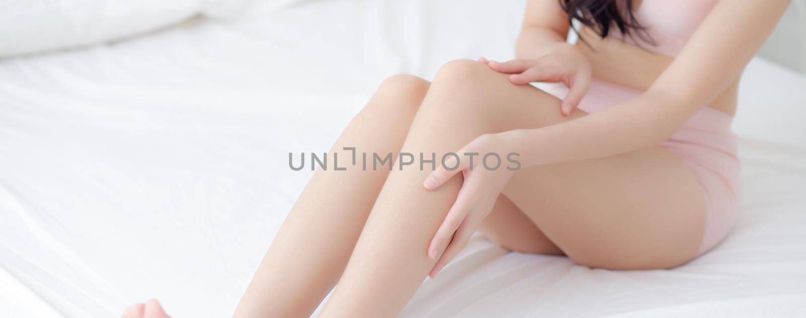 Beautiful young asian woman touch skin leg smooth with cream and lotion for hydration and smooth, girl applying body care and cosmetic, beauty perfect with wellness, health and care, banner website.