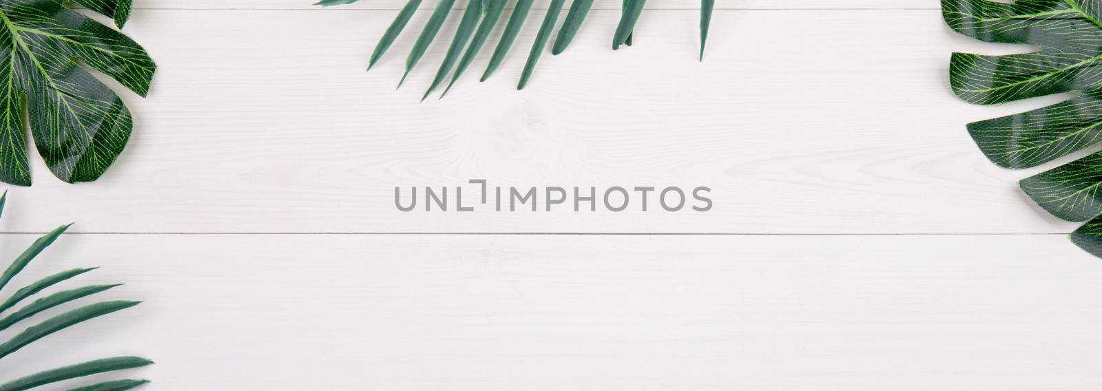 Leaf on wooden table, composition with top view, branch and leaves on wood desk with copy space, texture background, foliage tropical, nobody, flat lay, minimal concept, banner website. by nnudoo
