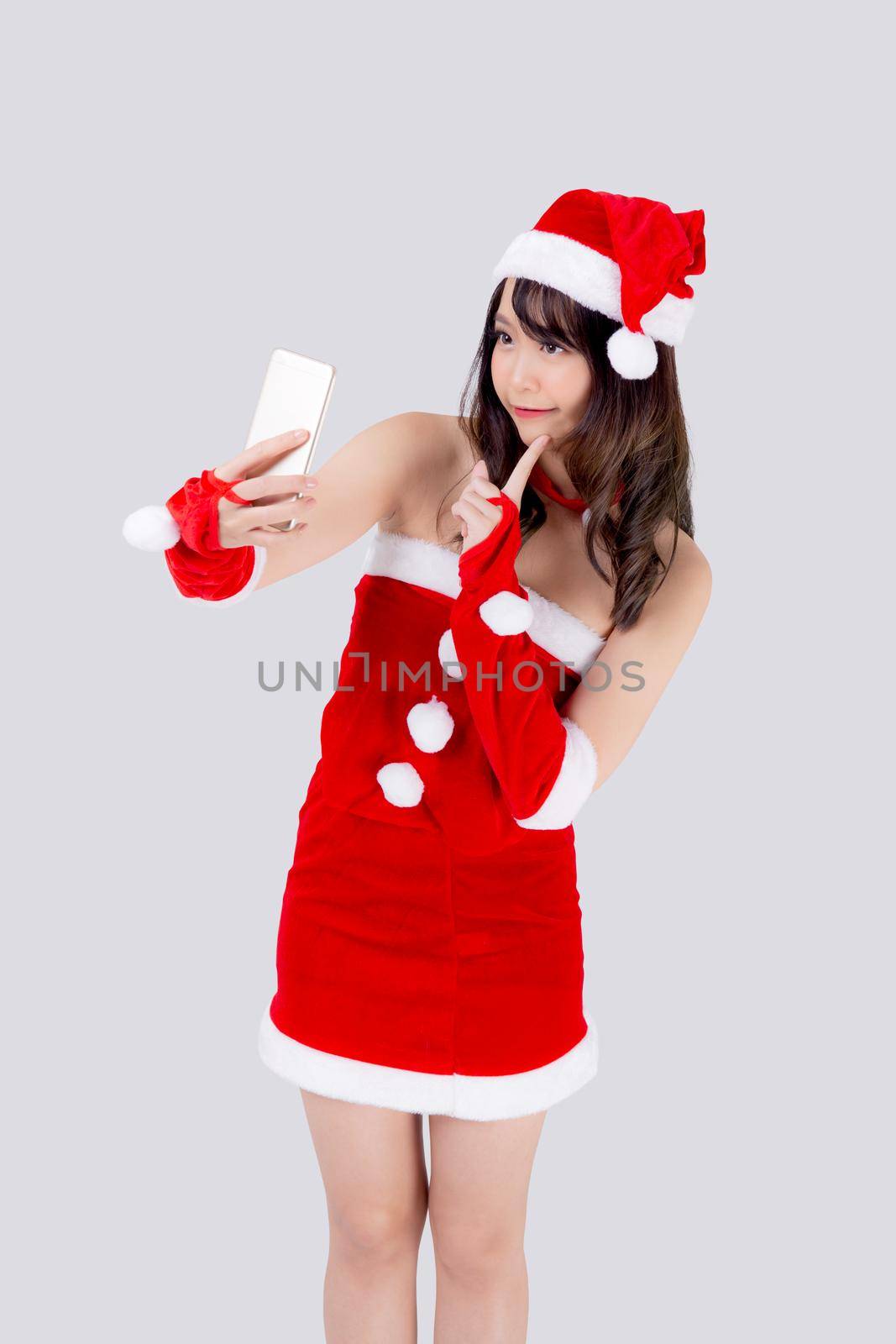 Beautiful portrait young asian woman in Santa cheerful taking a photo in Christmas holiday isolated on white background, asia girl selfie with phone celebrating in xmas with smiling and happy.
