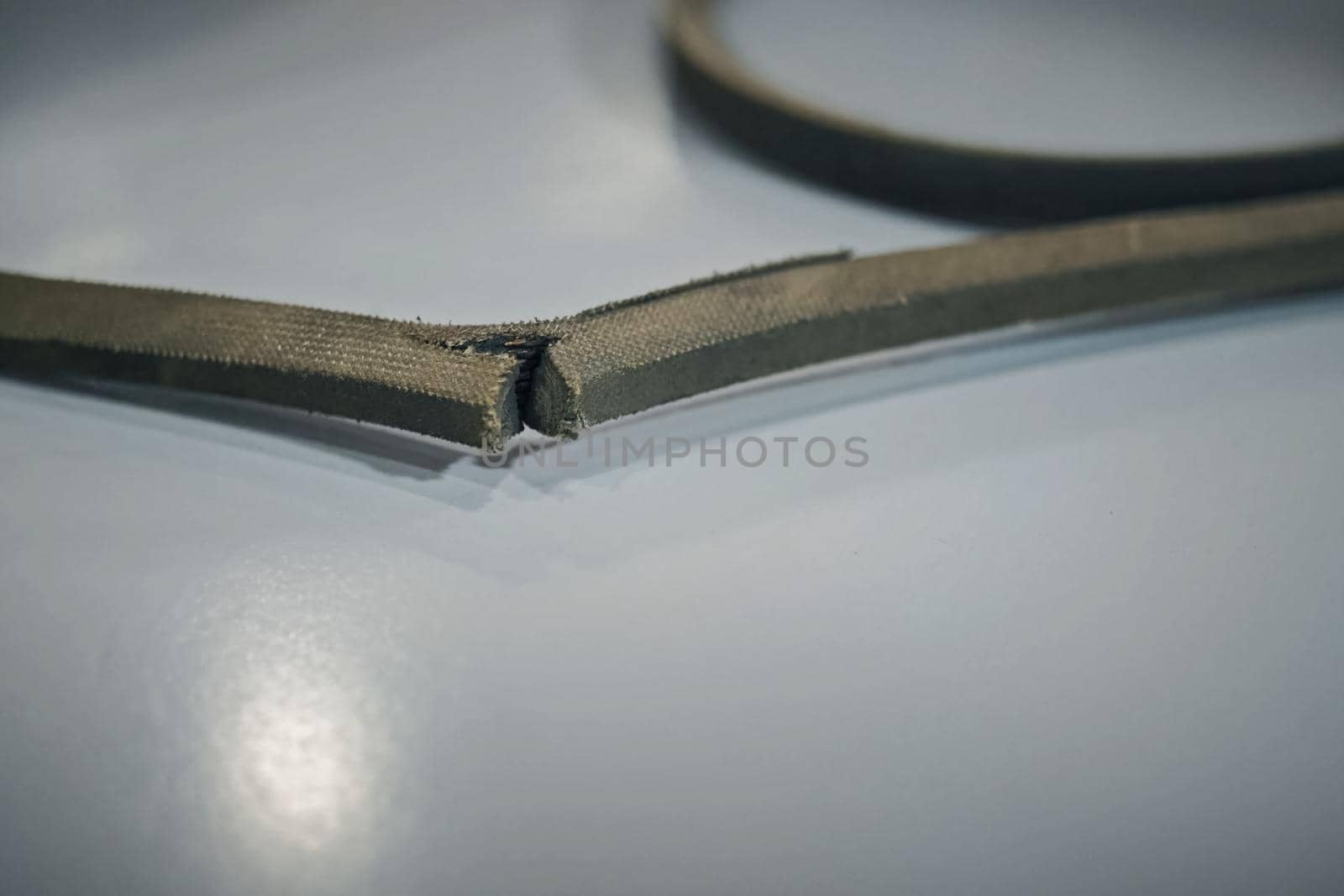 A torn rubber belt of belt transmission.