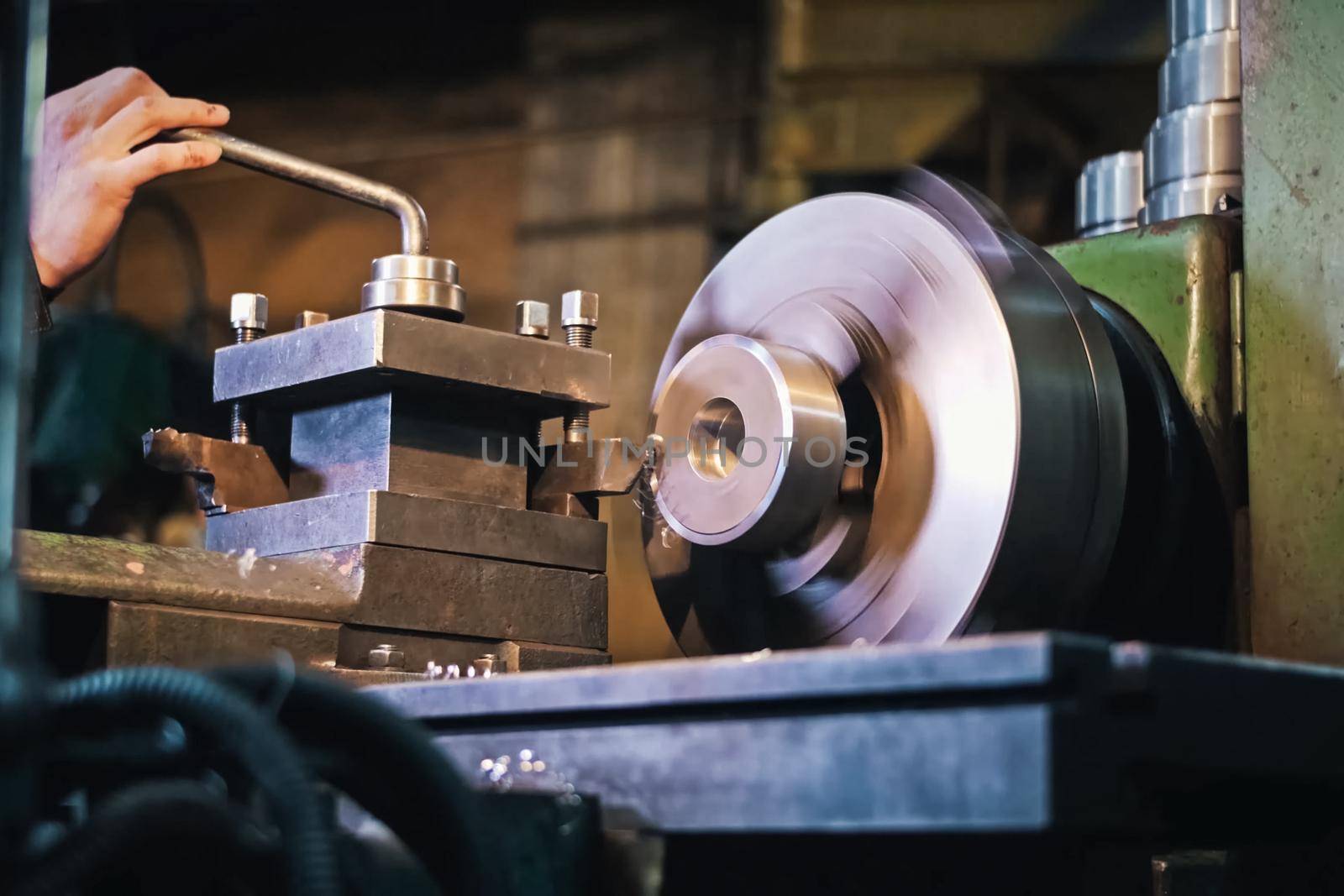 The worker stands at the machine on the sharpening of parts. by DePo