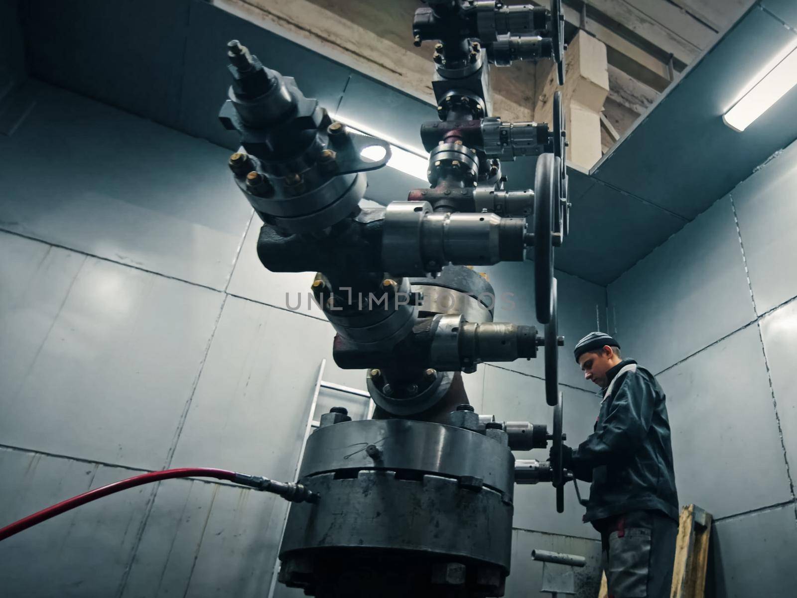 Assembling a well at the oil equipment plant. The connection of the valves and other well parts in the assembly hall.