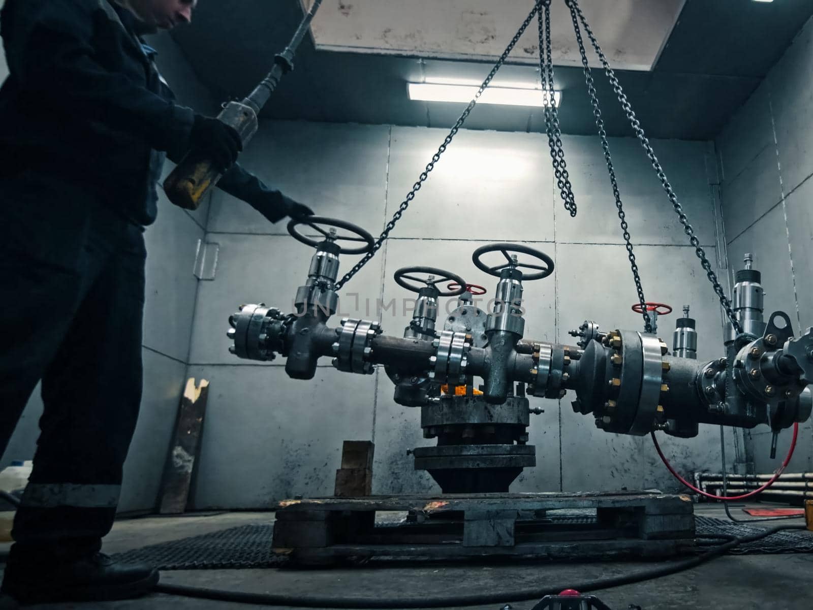 Assembling a well at the oil equipment plant. The connection of the valves and other well parts in the assembly hall.