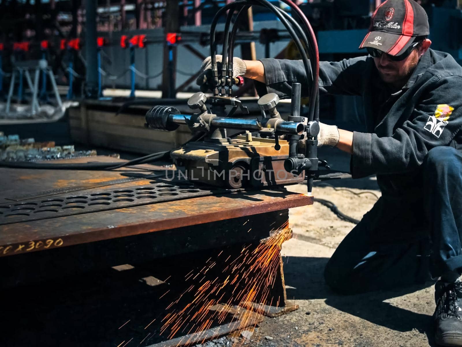 The worker cuts the sheet of metal with gas welding.