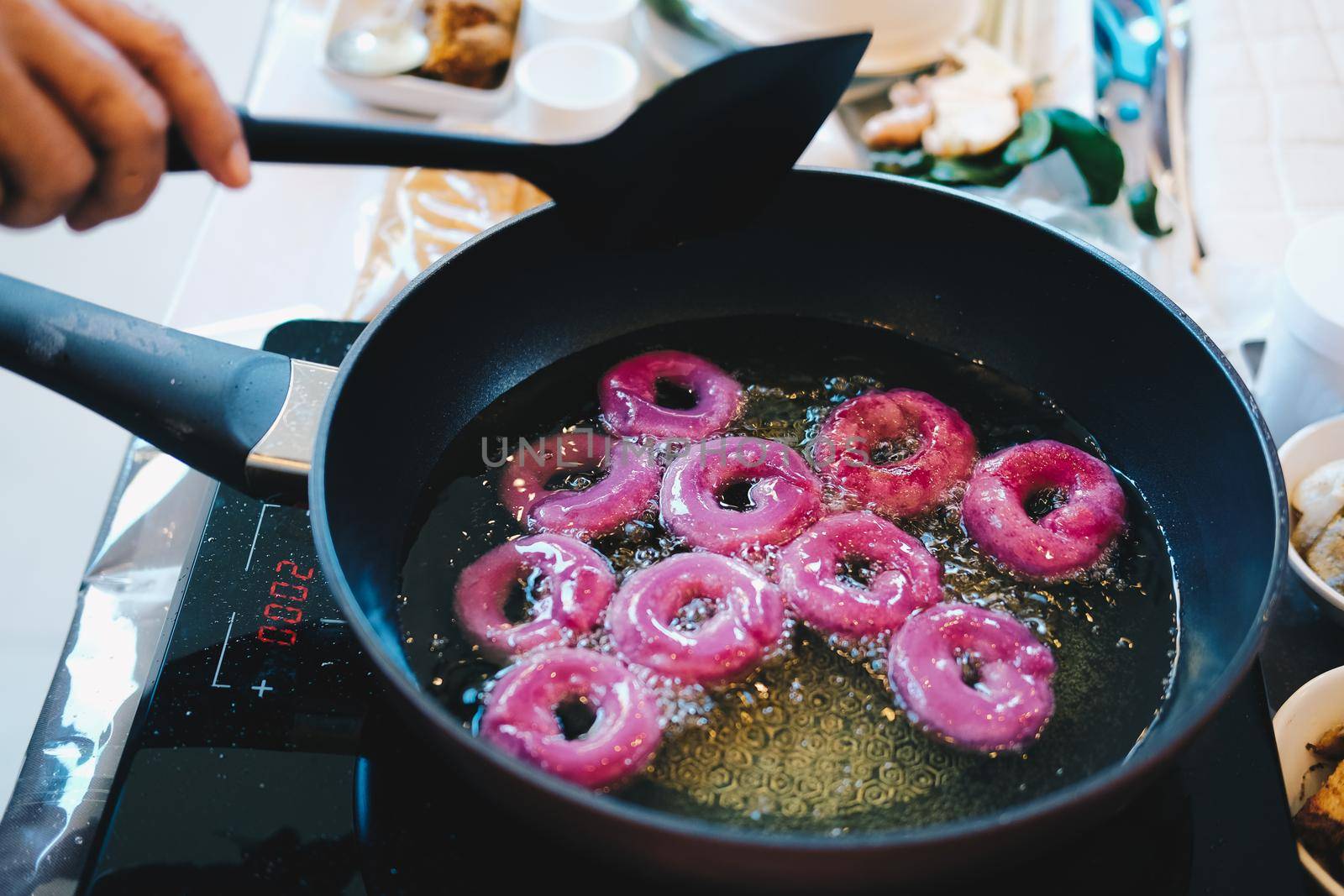 frying purple sweet potato doughnut. deep fried doughnuts dessert