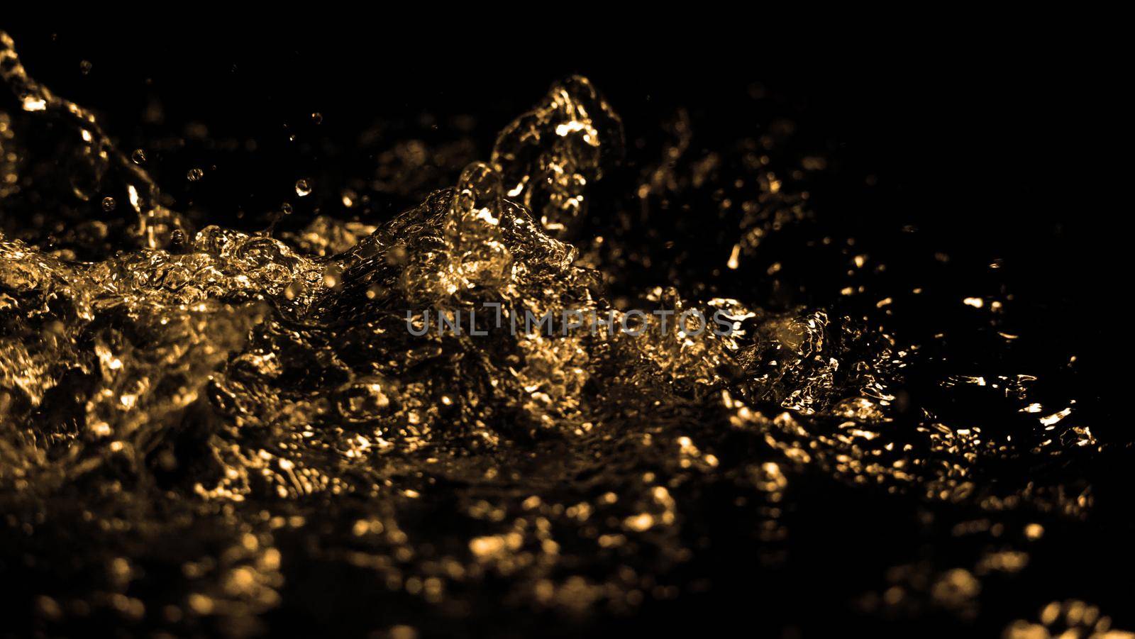 Hi speed close up images of oil liquid from diesel gasoline splashing and moving up to the air on black background for represent power of fuel liquid that active and powerful. studio shot premium gold color tone.