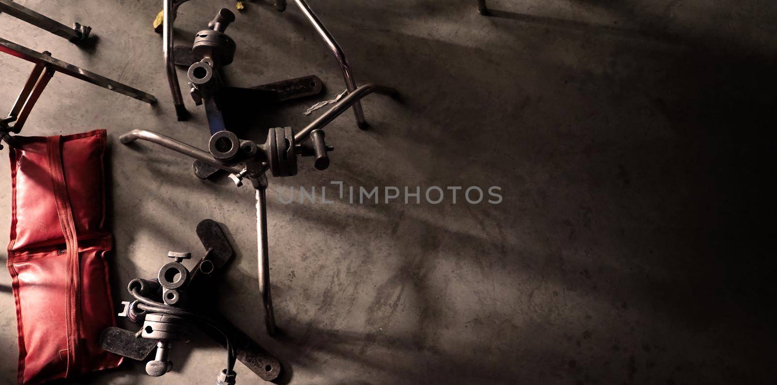 Background studio floor of filming or making of video production that include professional equipment such as many electric light wire and tripod and dolly wheel on it and look messy and a bit dirty.