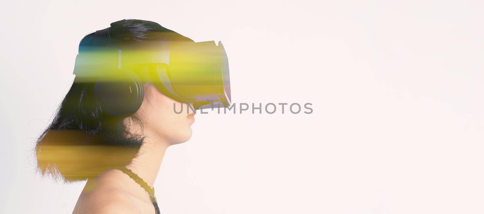 Asian teenage woman wearing VR or Virtual Reality head set  by gnepphoto