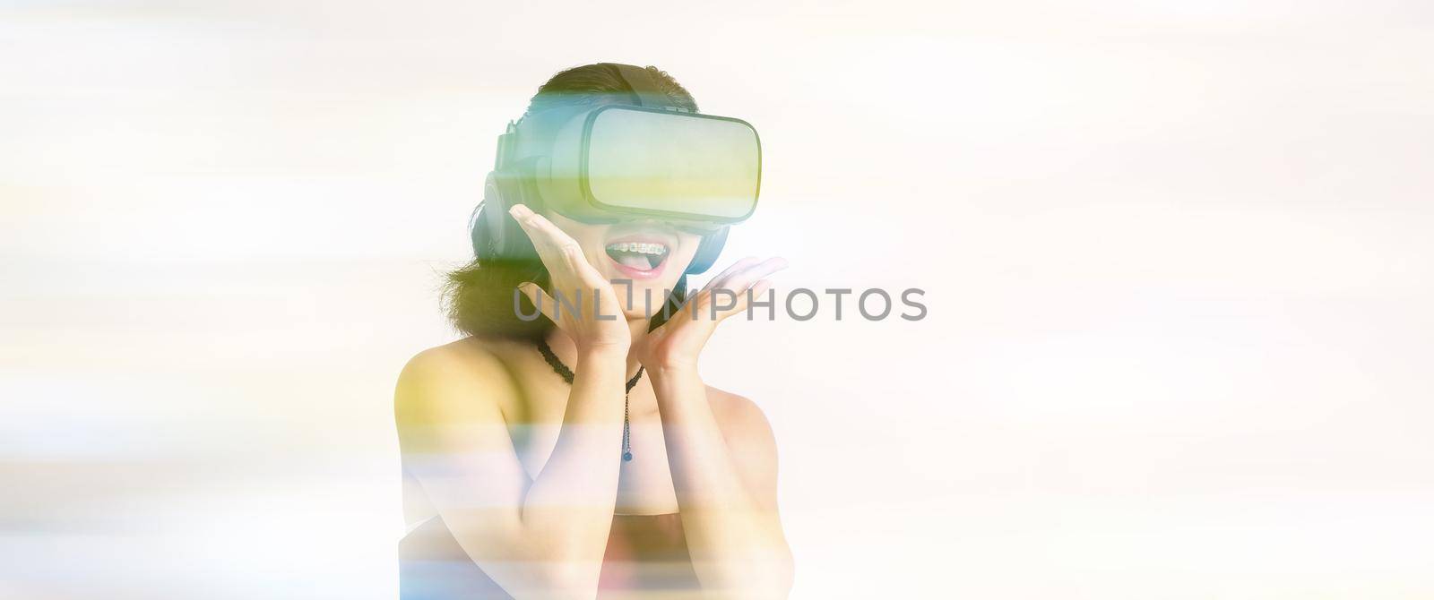 Asian teenage woman wearing VR or Virtual Reality head set and enter to the digital simulation world for learning and traveling or gaming  and more. Studio shot white background