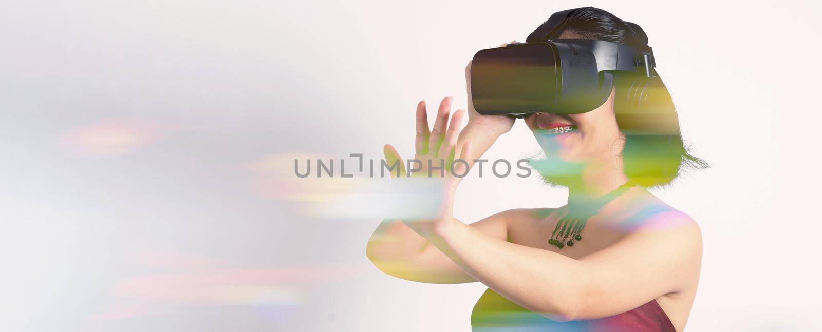 Asian teenage woman wearing VR or Virtual Reality head set  by gnepphoto