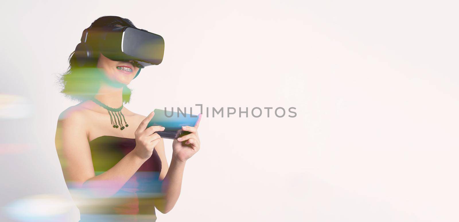 Asian teenage woman wearing VR or Virtual Reality head set and enter to the digital simulation world for learning and traveling or gaming  and more. Studio shot white background