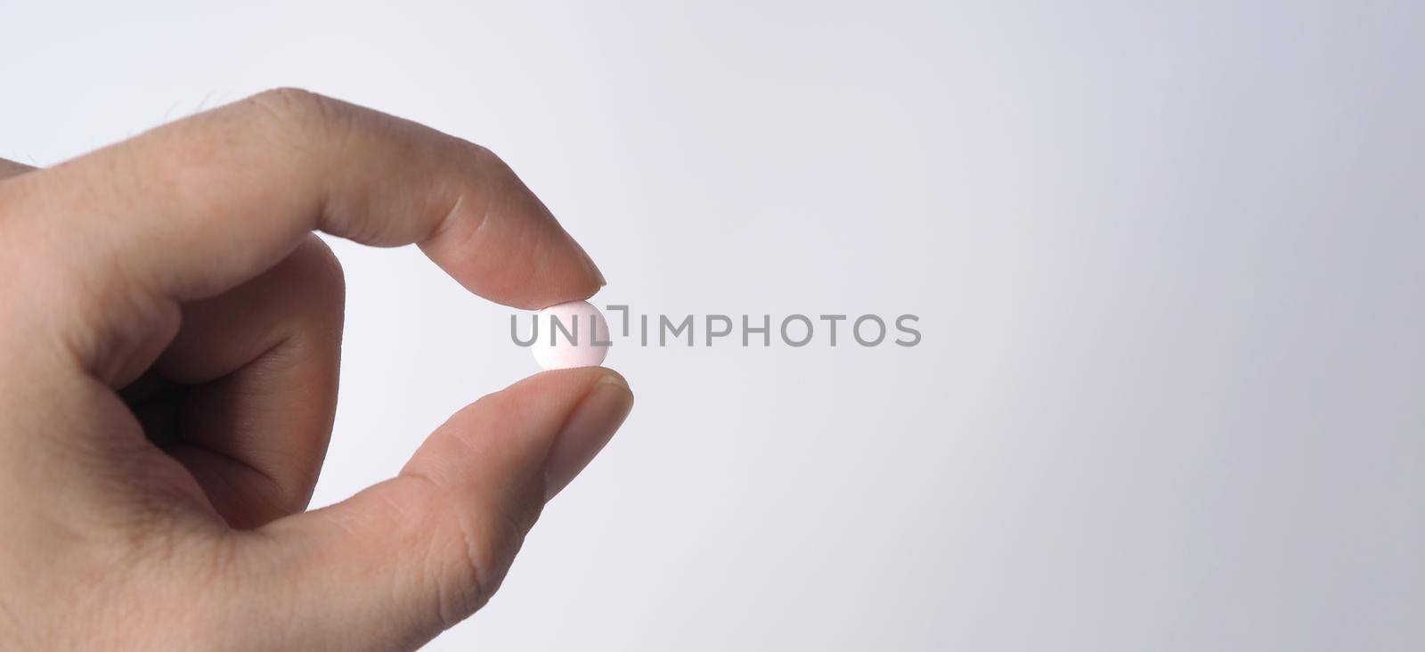 People taking or holding a white medicine pill in hand  by gnepphoto