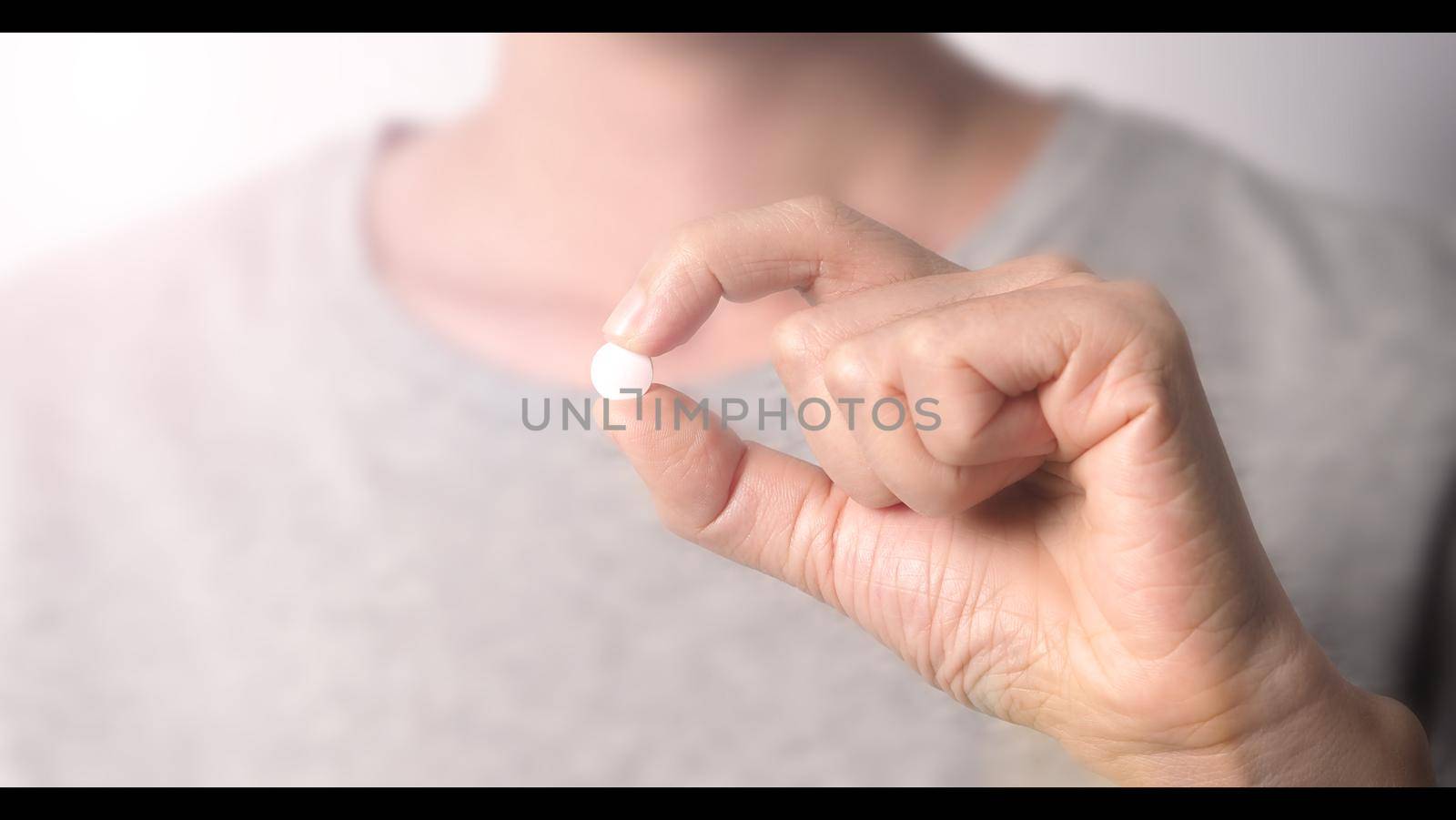 People taking or holding a white medicine pill in hand which help and protect from pandemic virus and relief them from unhealthy and sickness. studio close up shot and clear background.