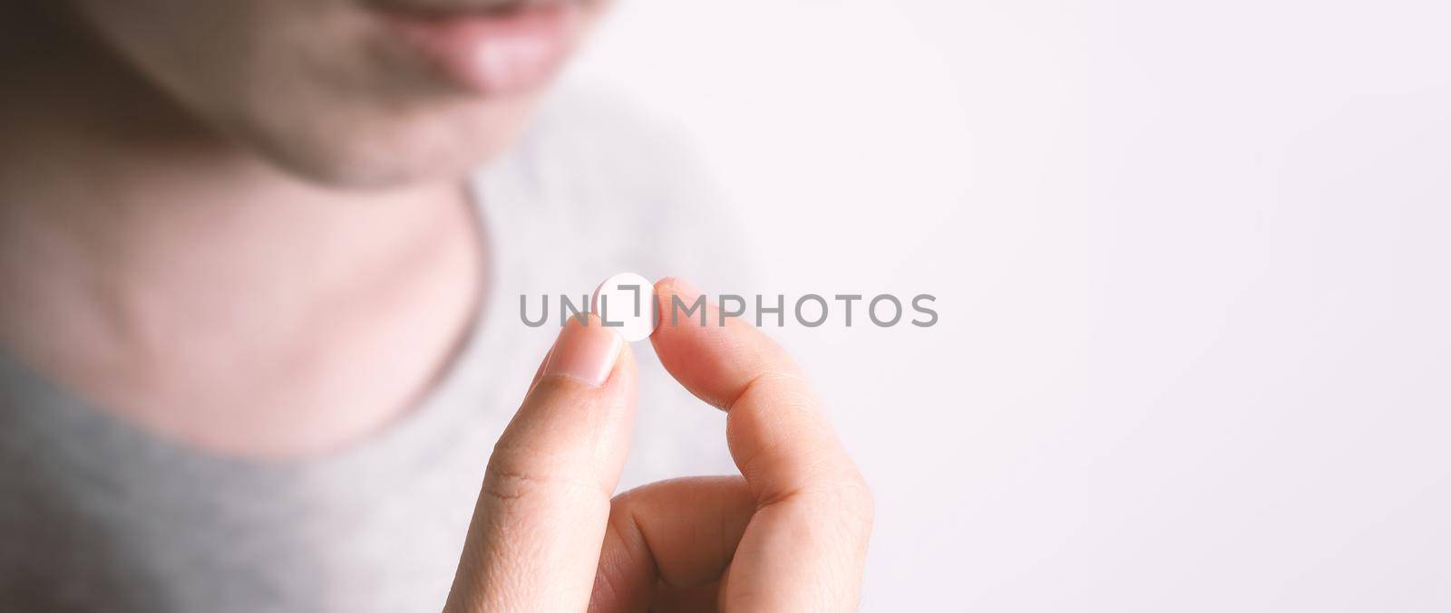 People taking or holding a white medicine pill in hand which help and protect from pandemic virus and relief them from unhealthy and sickness. studio close up shot and clear background.