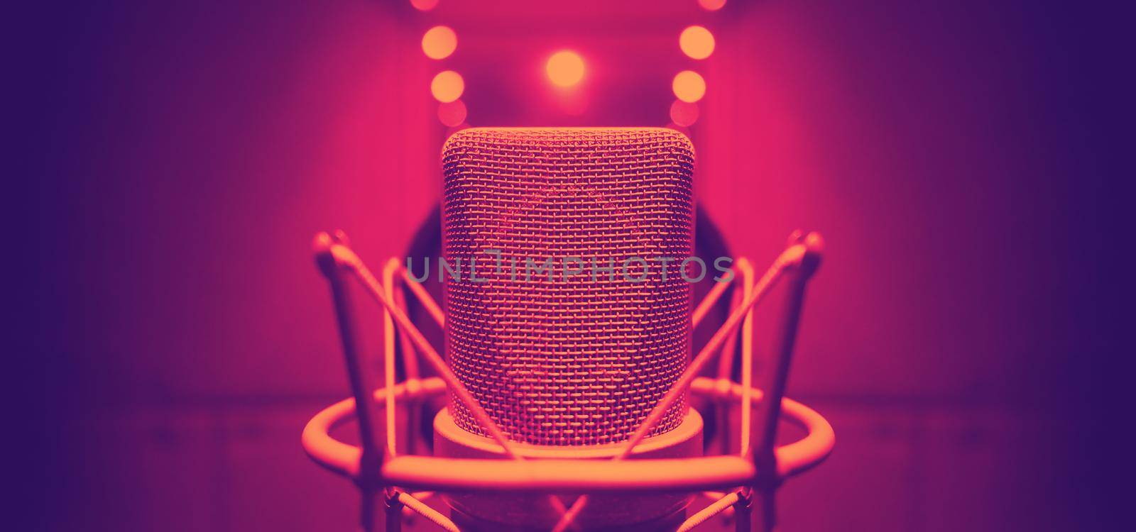 Studio microphone with shock mount and pop filter on tripod stand for sound engineer and singer or announcement on air studioroom. microphone and equipment concept.