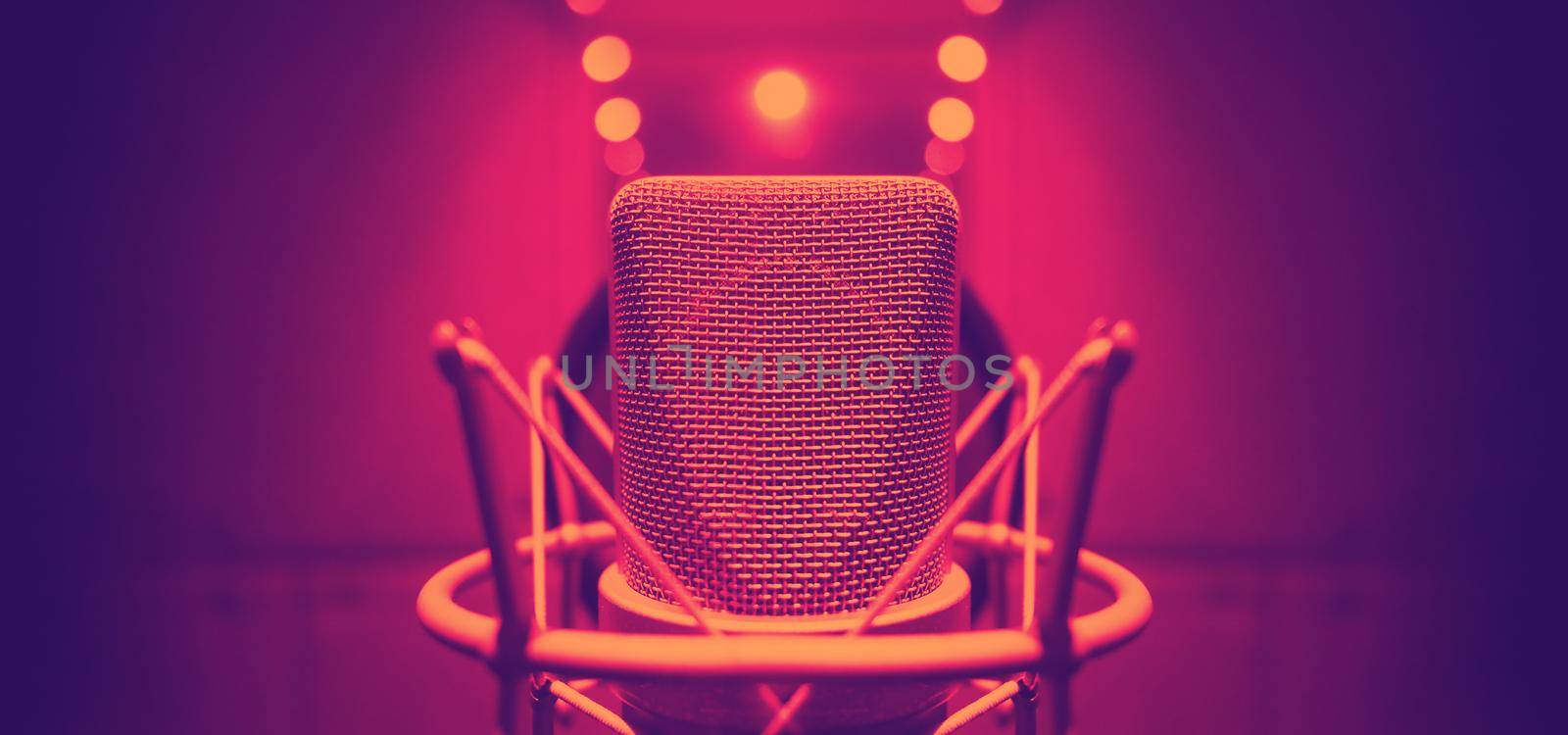 Studio microphone with shock mount and pop filter on tripod stand for sound engineer and singer or announcement on air studioroom. microphone and equipment concept.