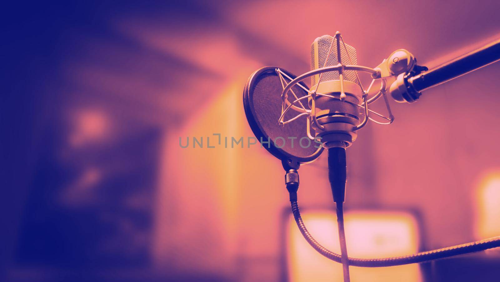 Studio microphone with shock mount and pop filter on tripod stand for sound engineer and singer or announcement on air studioroom. microphone and equipment concept.