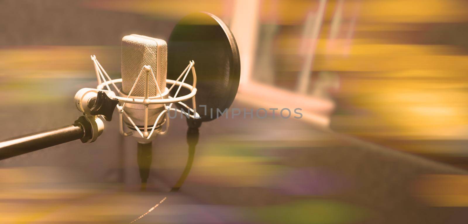 Studio microphone with shock mount and pop filter on tripod stand for sound engineer and singer or announcement on air studioroom. microphone and equipment concept.