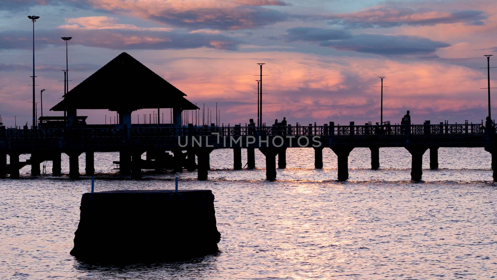 Bangsan Chonburi Thailand jetty and sunset. At Bangsan beach. Ao Thai Ocean. Beautiful sunset landscape, wooden shore jetty and colorful sky and cloud. Artistic beach sunset under wonderful sky. Recreation concept.