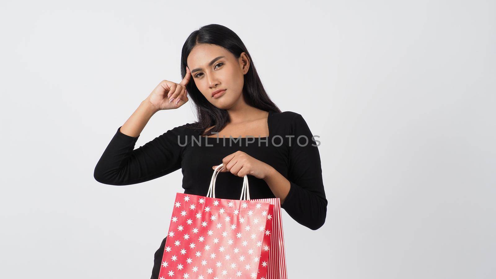 Happy shopping concept. Young asian Thai woman in action or activity of purchasing goods from stores or online shop. Happily girl and shopping bags during sale season in studio white background