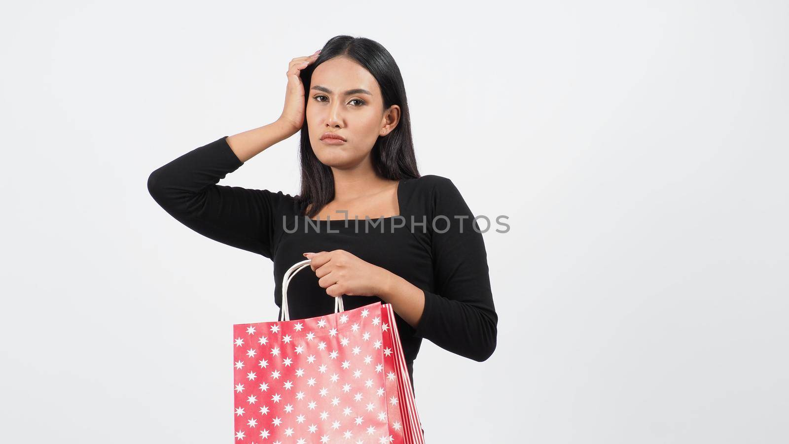 Happy shopping concept. Young asian Thai woman in action or activity of purchasing goods from stores or online shop. Happily girl and shopping bags during sale season in studio white background