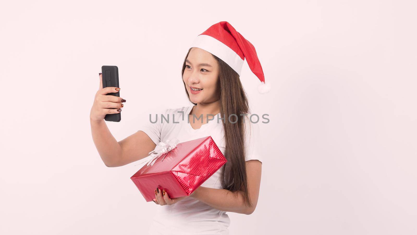 Girl hold gift box make selfie or video online with x-mas christmas prop accessories by gnepphoto