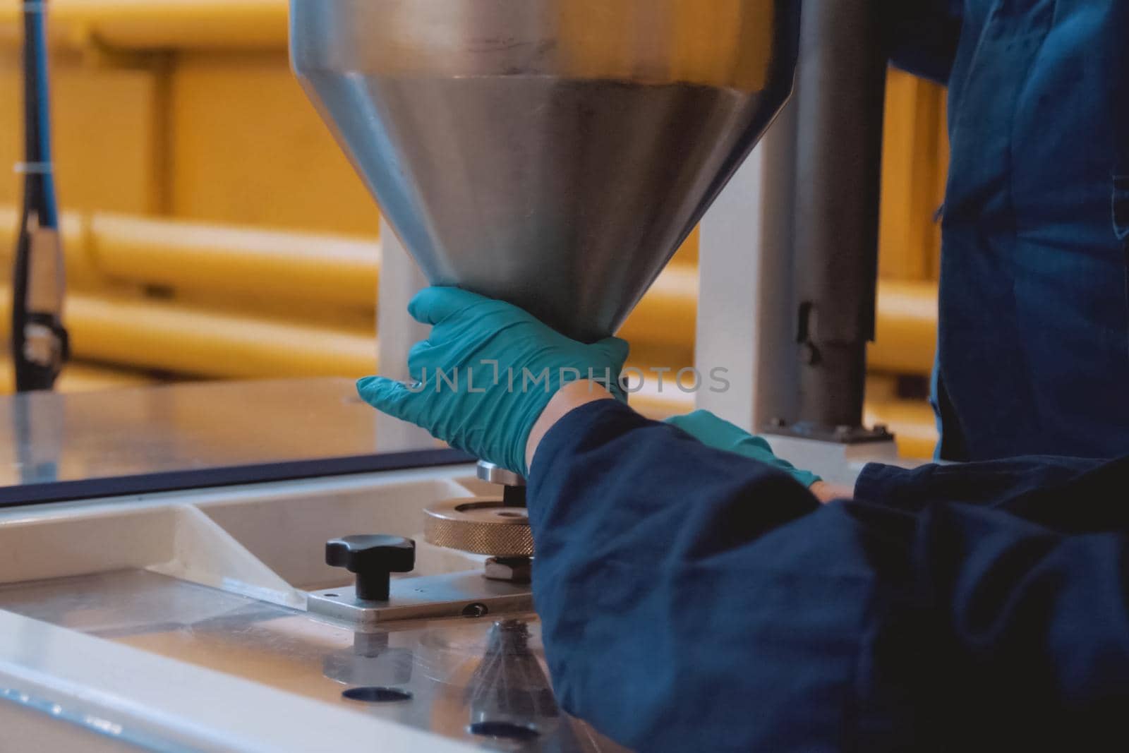 A worker at the plant holds a funnel with a filler.