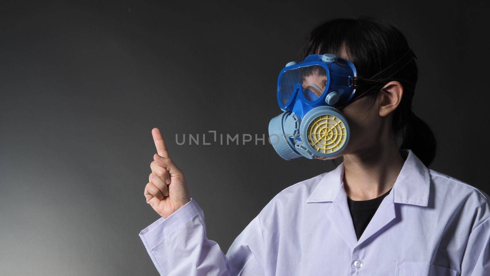 Asian woman doctor in a chemical protective medical mask and protective goggles. Doctor uniform clothing and half mask replaceable particulate filter respirator. Women scientist safety mask