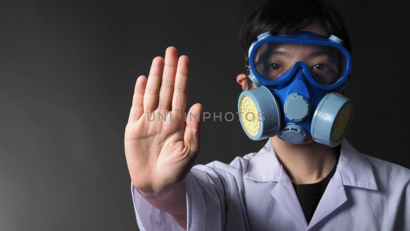 Asian woman doctor in a chemical protective medical mask and protective goggles. Doctor uniform clothing and half mask replaceable particulate filter respirator. Women scientist safety mask