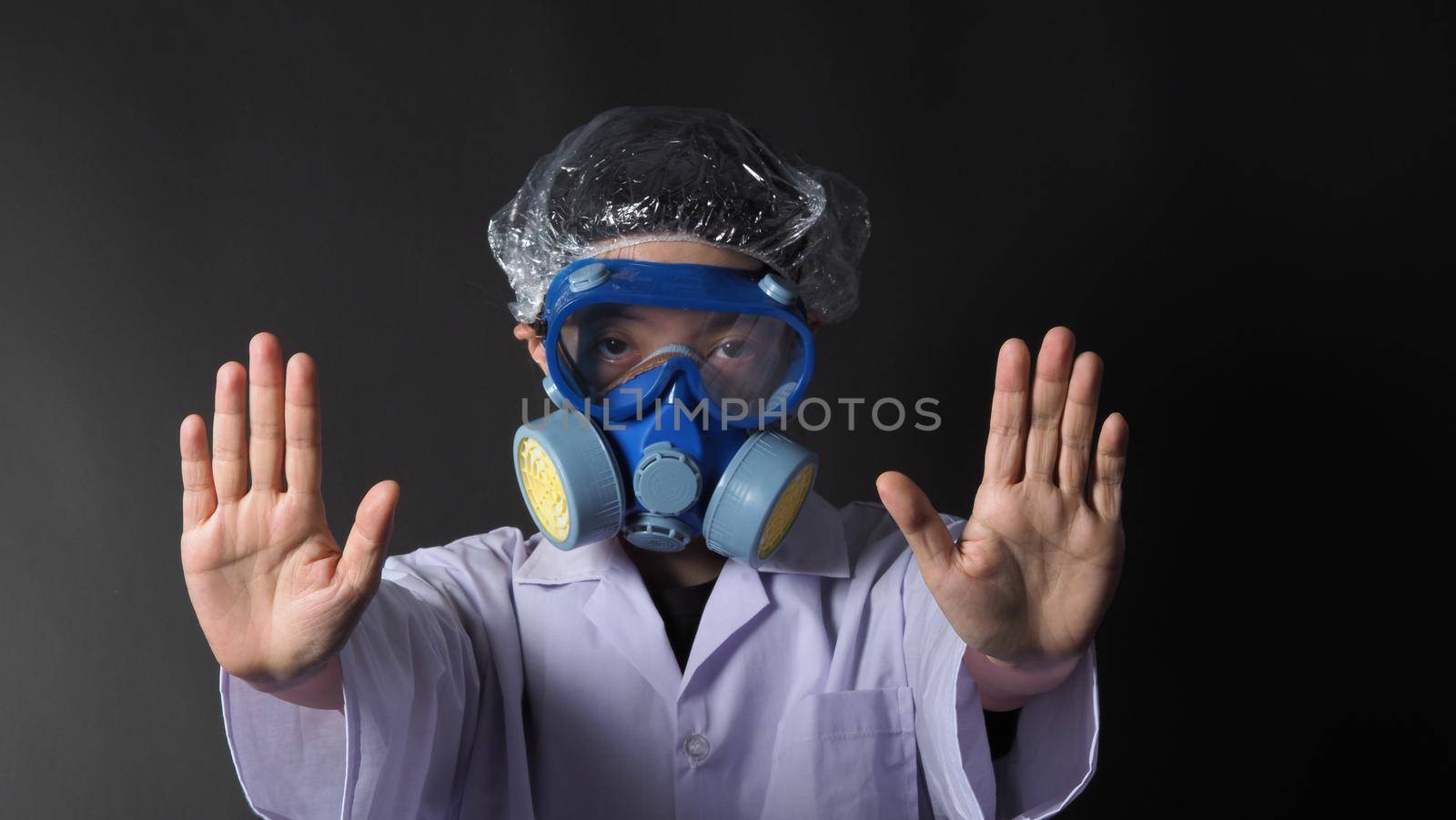 Asian woman doctor in a chemical protective medical mask and protective goggles. Doctor uniform clothing and half mask replaceable particulate filter respirator. Women scientist safety mask