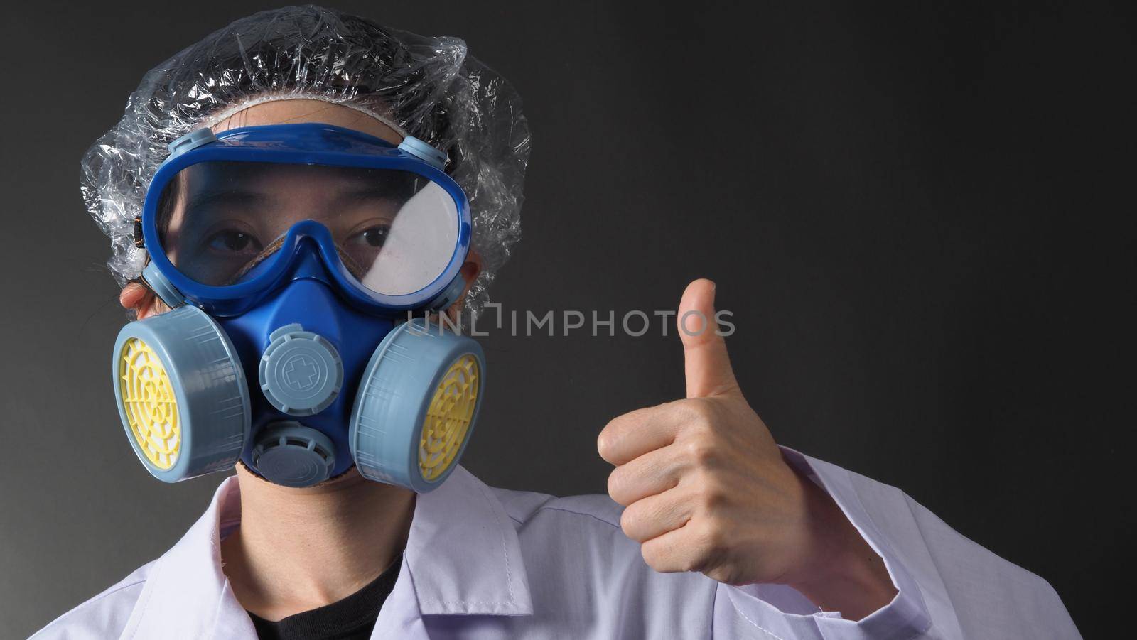 Asian woman doctor in a chemical protective medical mask and protective goggles. Doctor uniform clothing and half mask replaceable particulate filter respirator. Women scientist safety mask