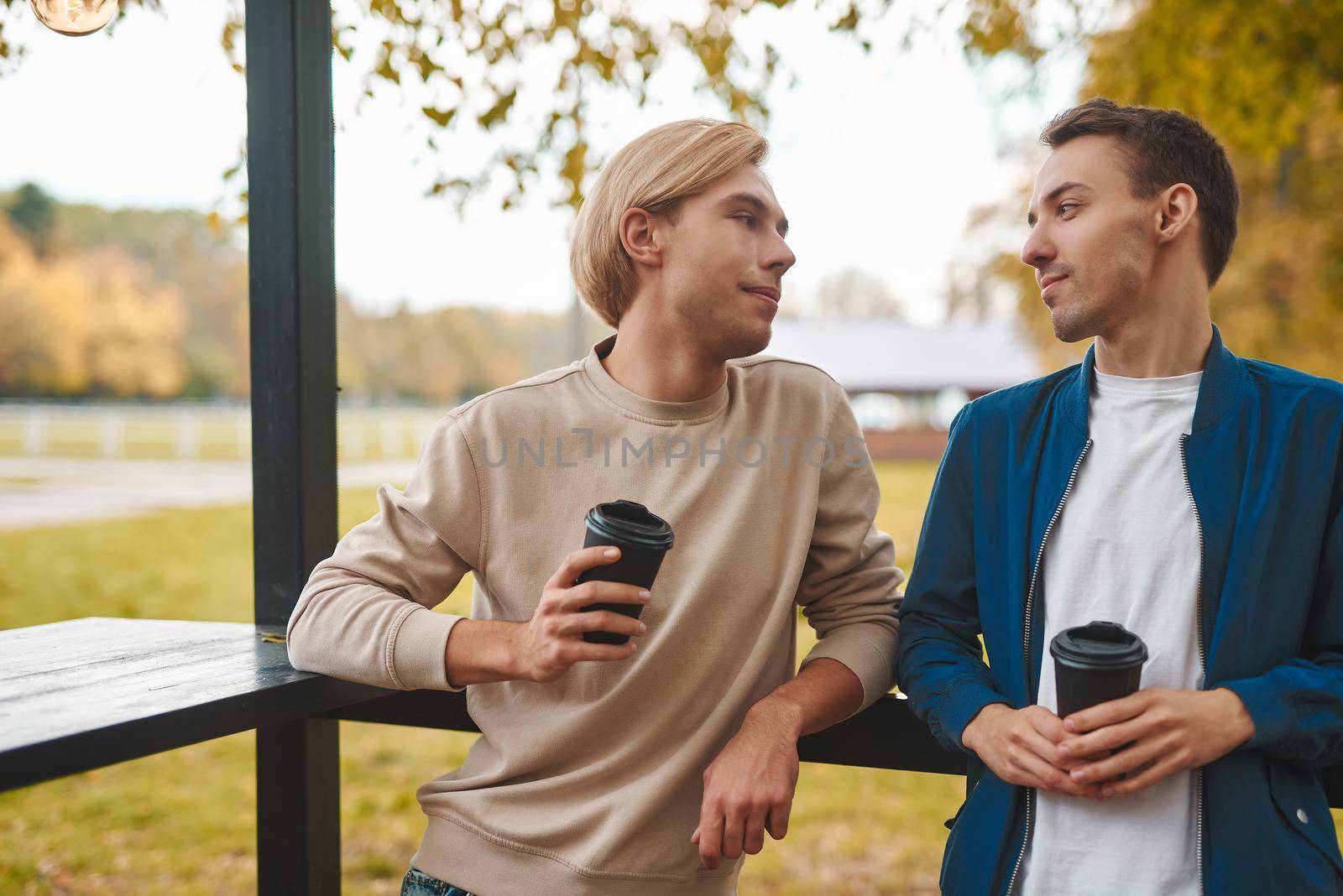 Loving gay couple outdoors. Two handsome men having romantic date in park. LGBT concept.