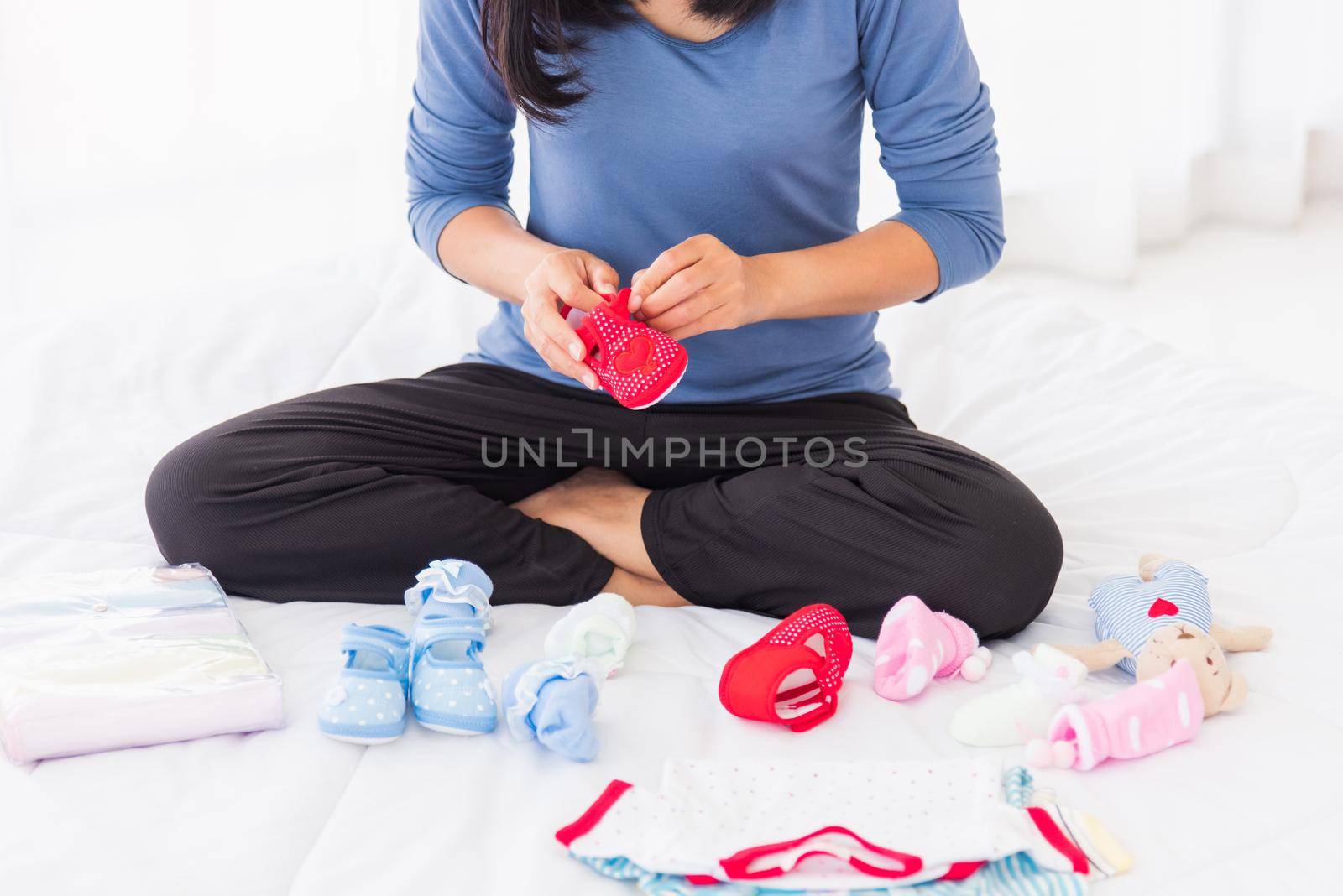 mother preparing baby clothes resting and relaxing on the bed by Sorapop