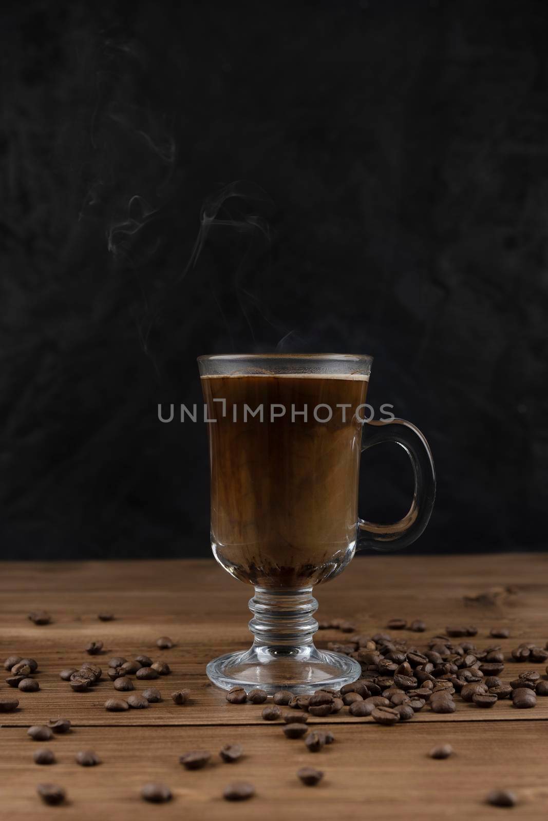 Steaming coffee over wooden surface and black background by sashokddt