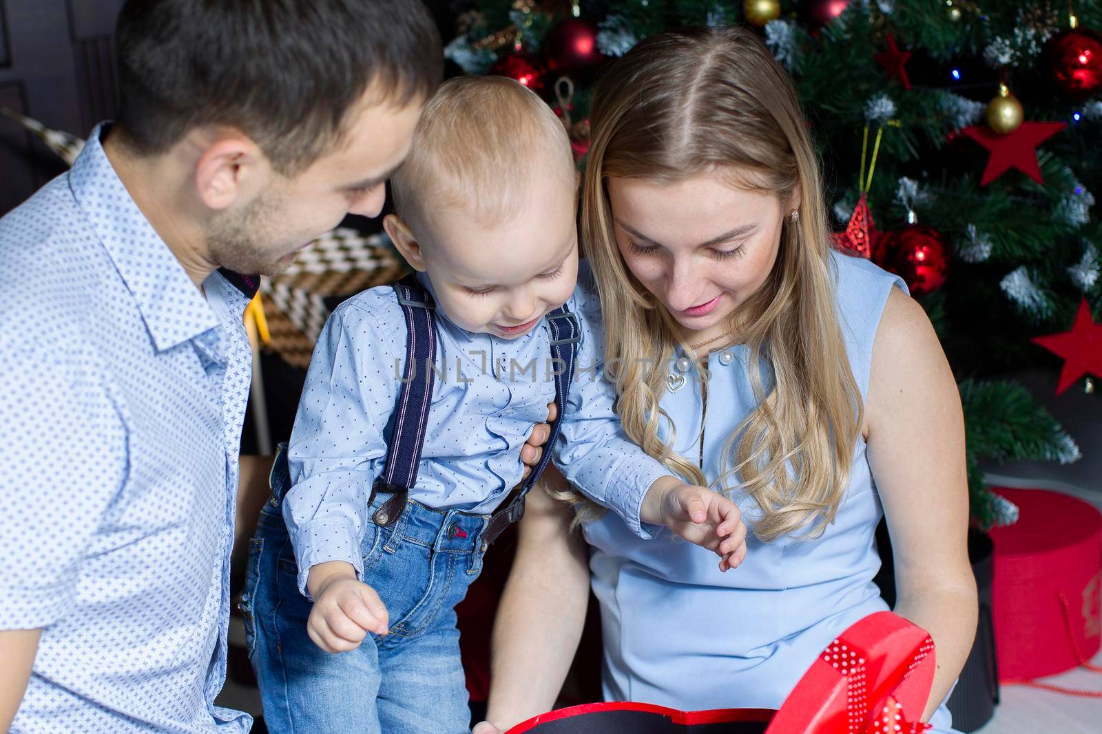 Family at Christmas. Mom dad and son at the Christmas tree