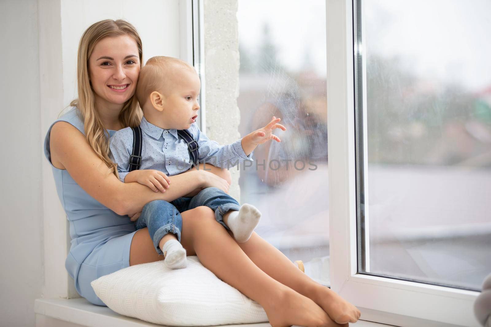 Mom with her son at home near the window.