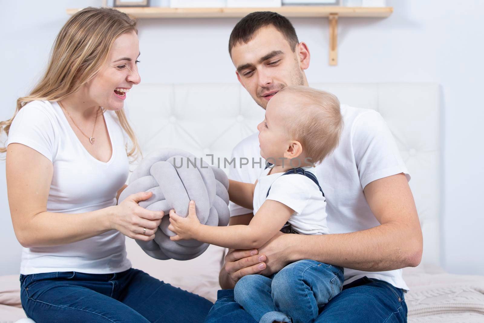 Mom, dad and little son are playing at home. Young family with a child.