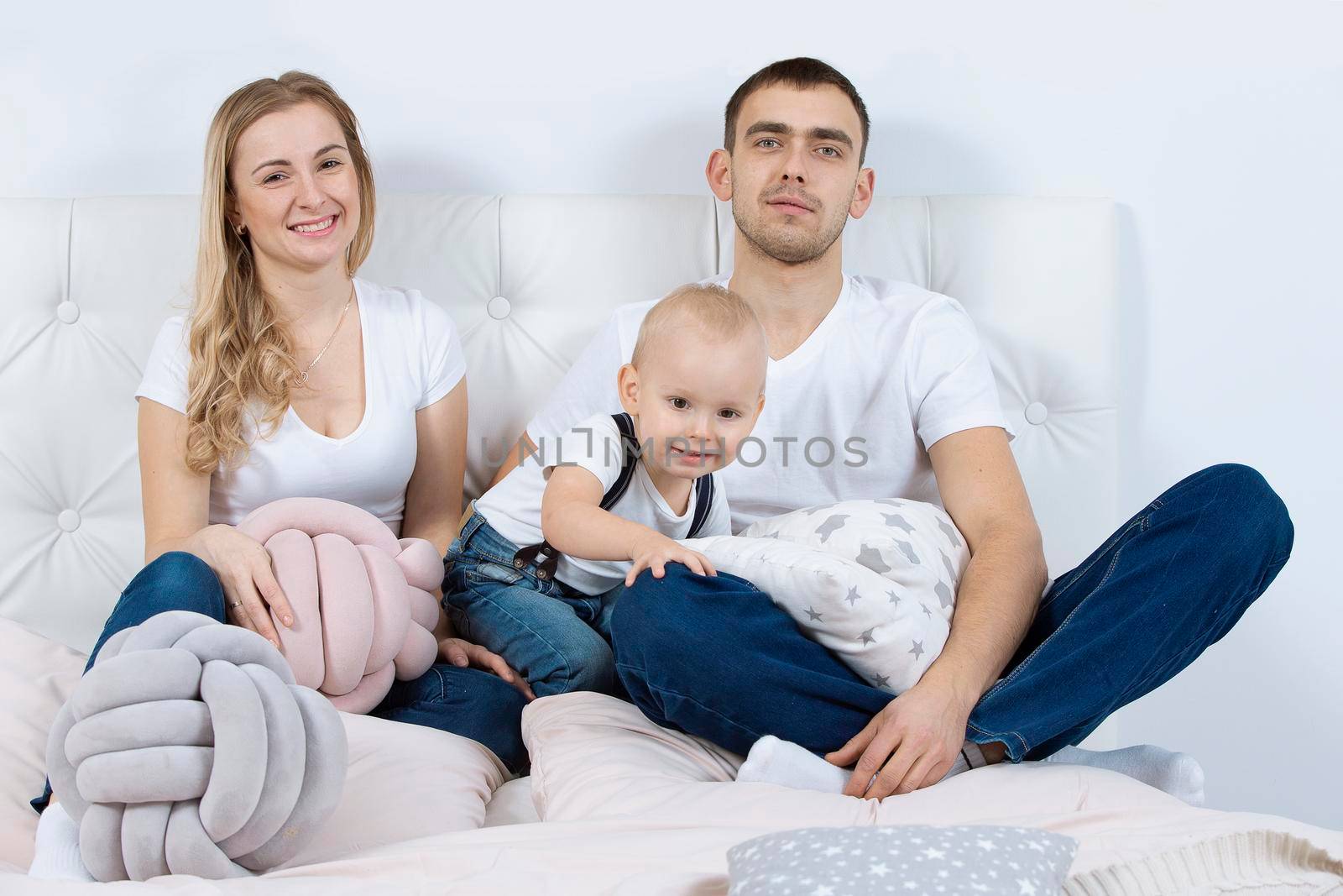 Mom, dad and little son are playing at home. Young family with a child.