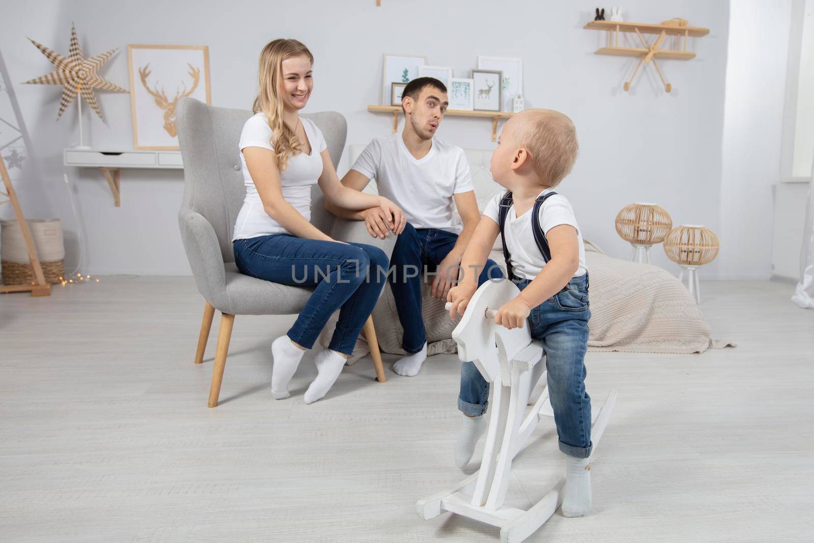 Family. Dad mom child play at home. Husband wife and little son. Couple with baby in the apartment