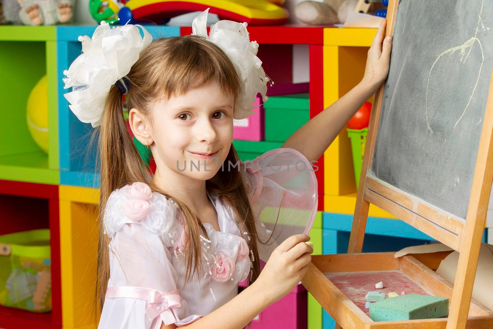 Girl preschooler. Primary school student at the blackboard.
