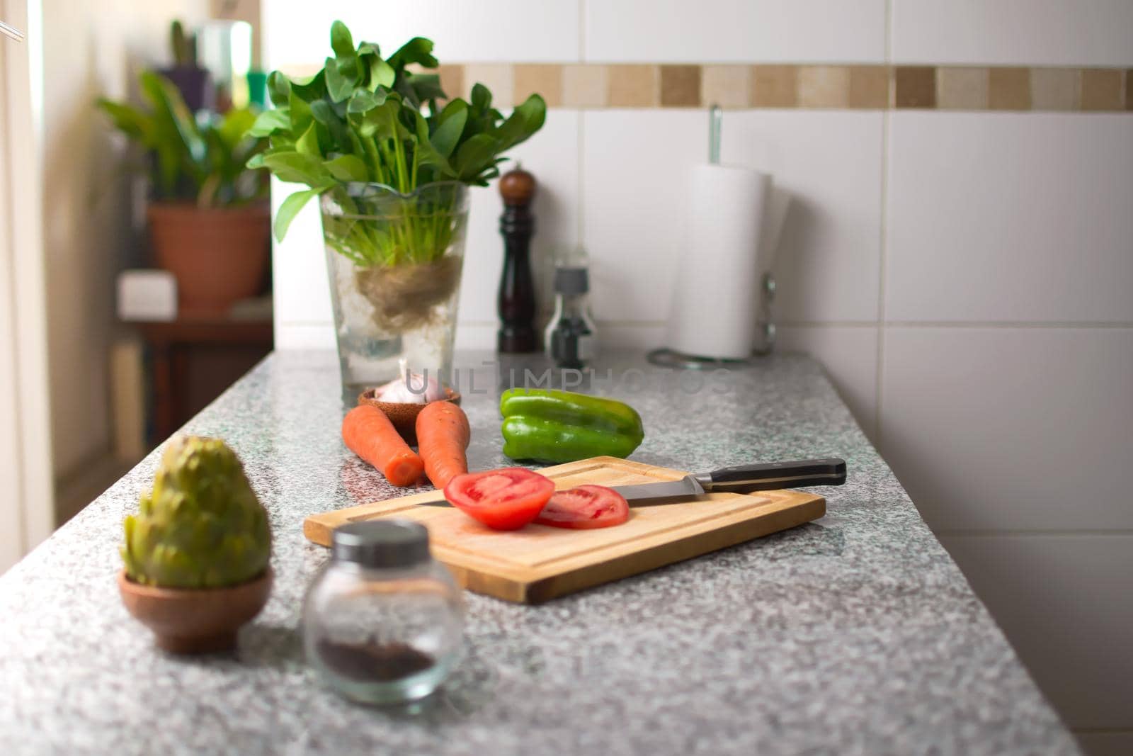 Bell pepper on a cutting board, and fresh ingredients over a kitchen countertop.