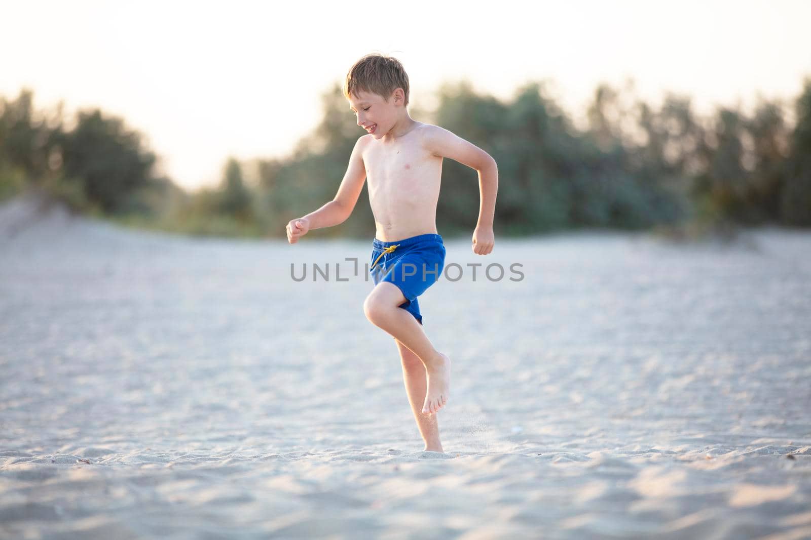 A child plays on the sandy shore. Boy playing on the beach
