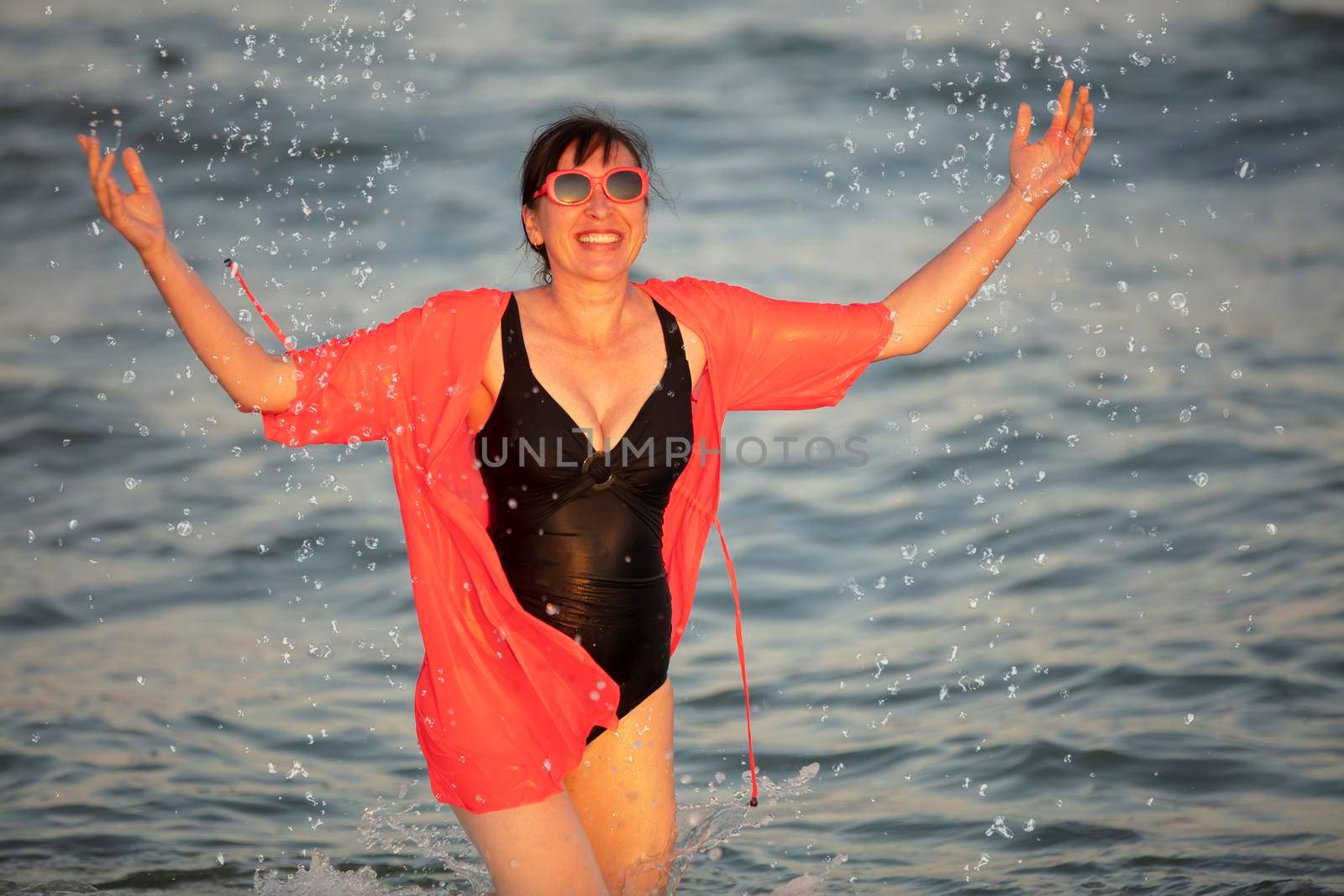 Happy woman at the sea with splashes by Sviatlana