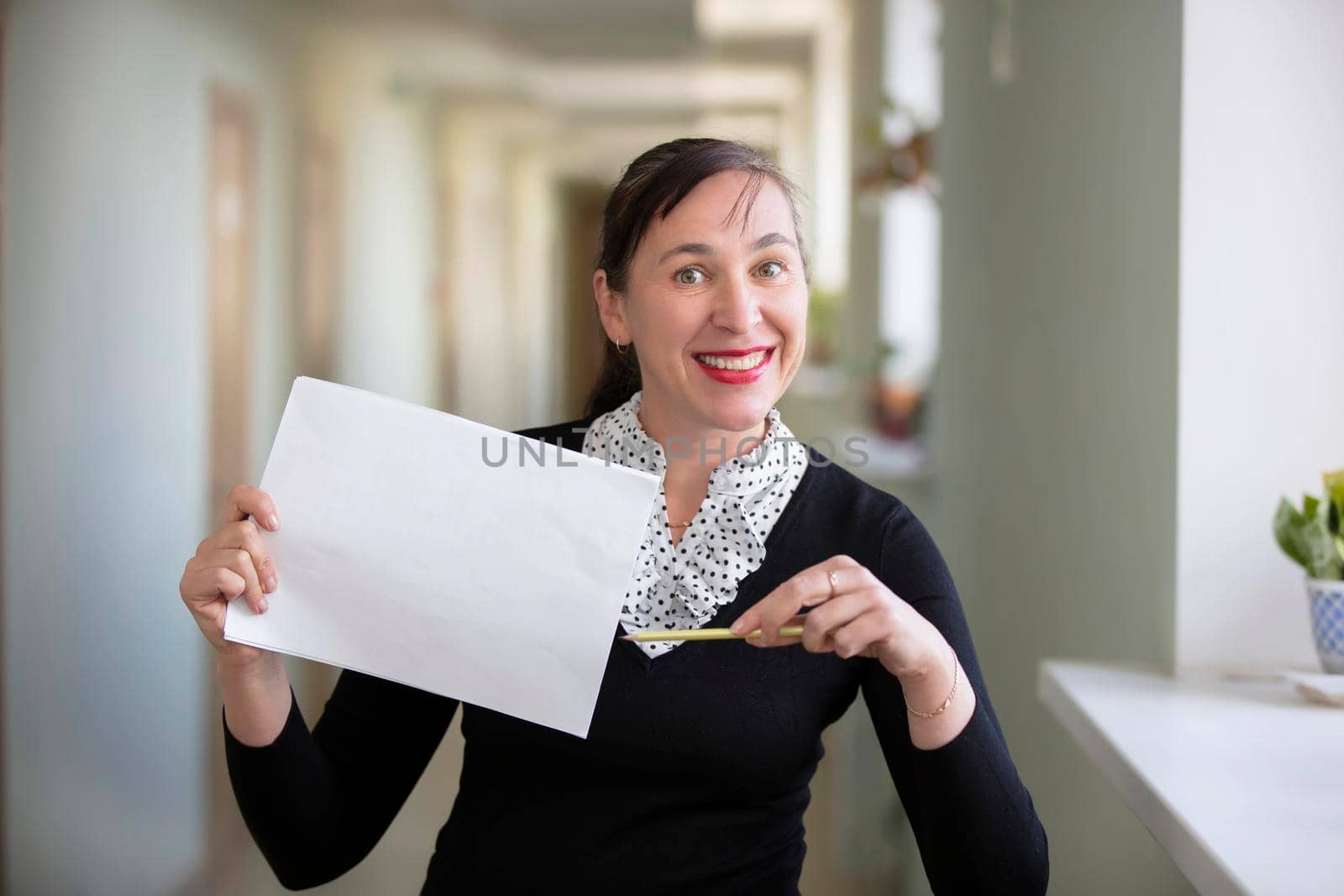 Woman in the office shows on a piece of paper