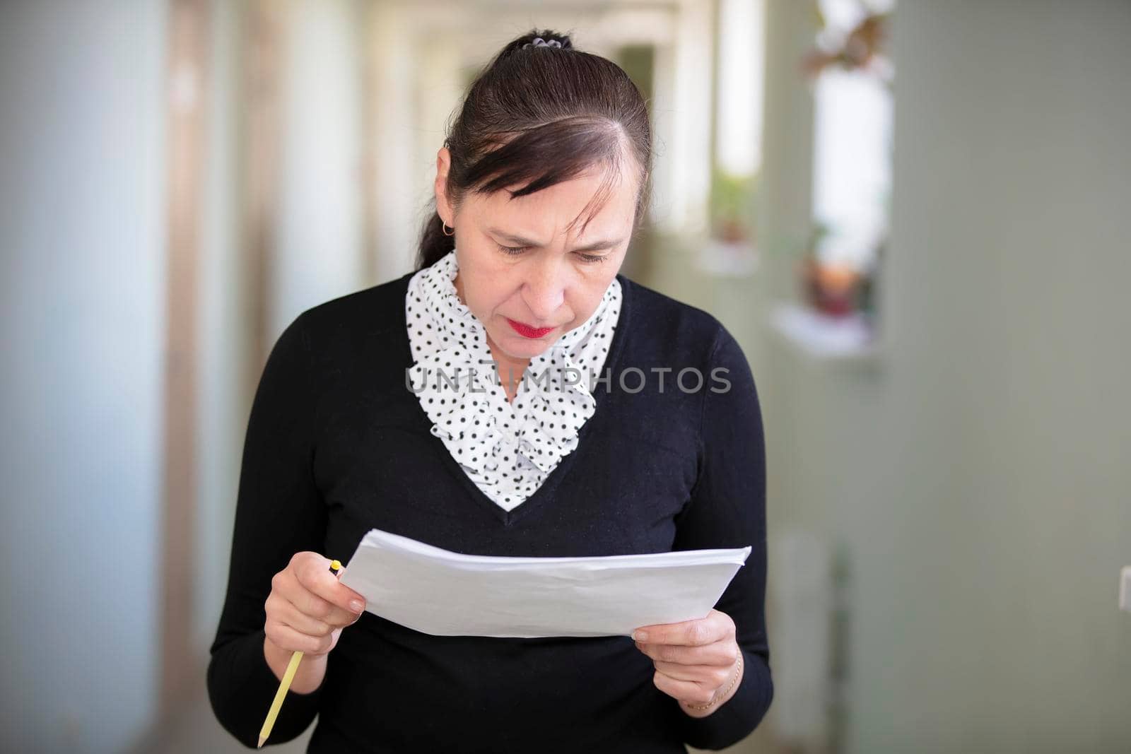 Woman at work. Female employee in the office corridor with paper.