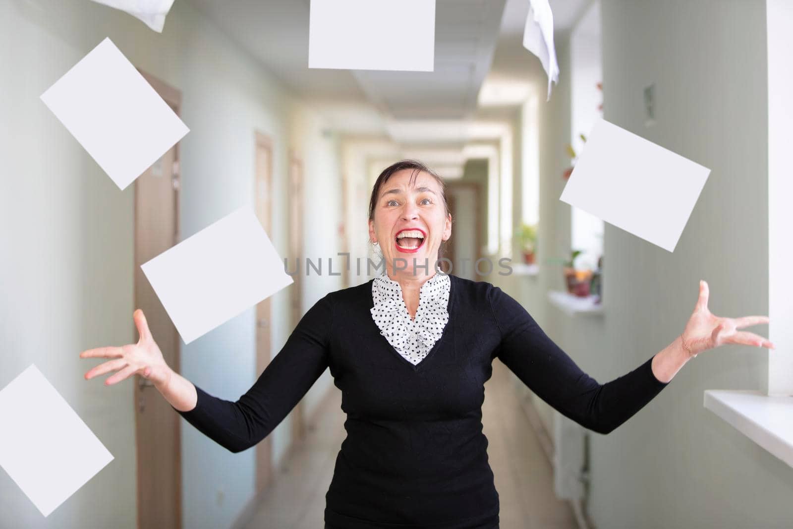 A woman in the office scatters papers. Nervous employee.