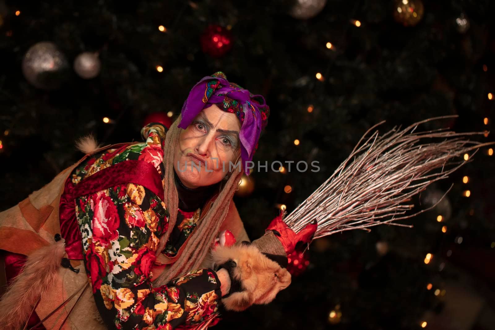 Baba Yaga with a broom on the background of the Christmas tree.Russian witch.