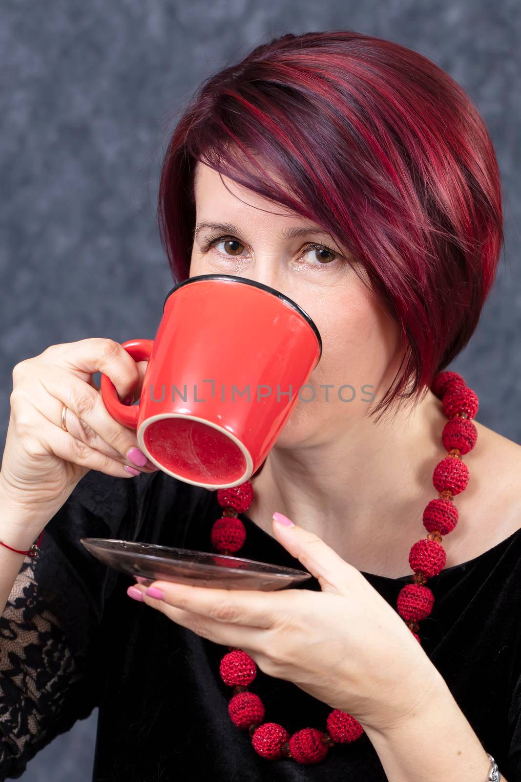 A woman is drinking from a red cup.