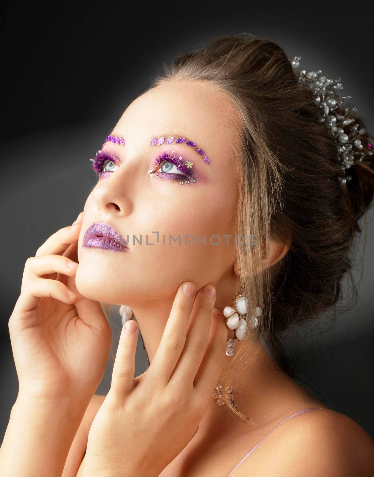 Model girl with bright makeup. Fashion makeup. Woman with violet restresses and eyebrows. Beautiful young face.